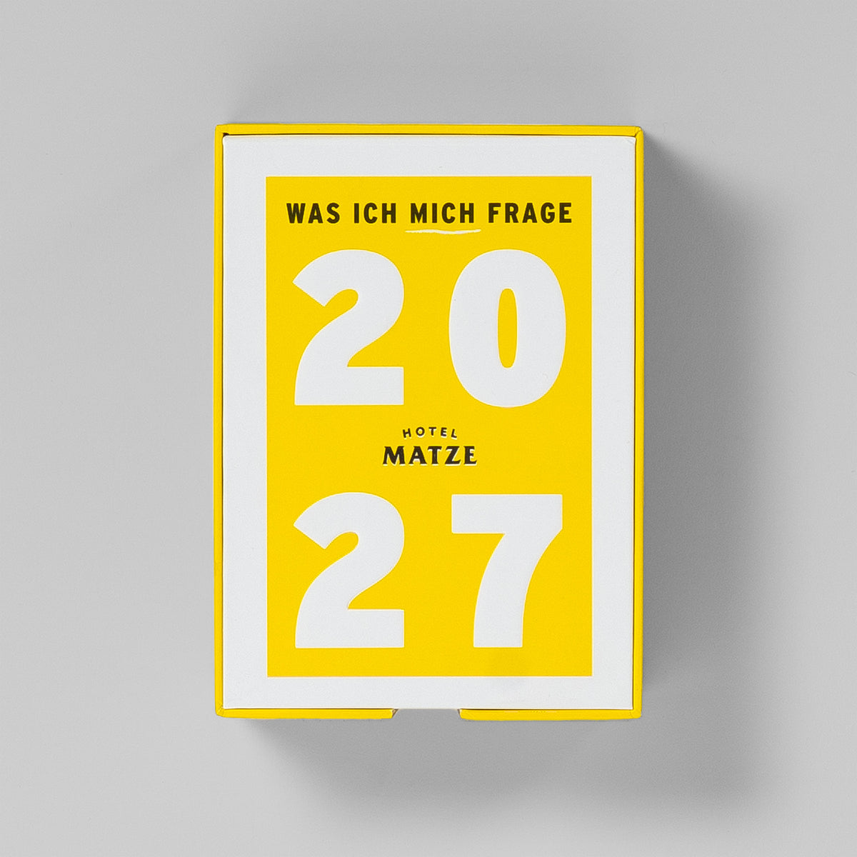 Sammelbox von oben: weißer Deckel mit gelbem Feld, Titel »Was ich mich frage« und große 2027