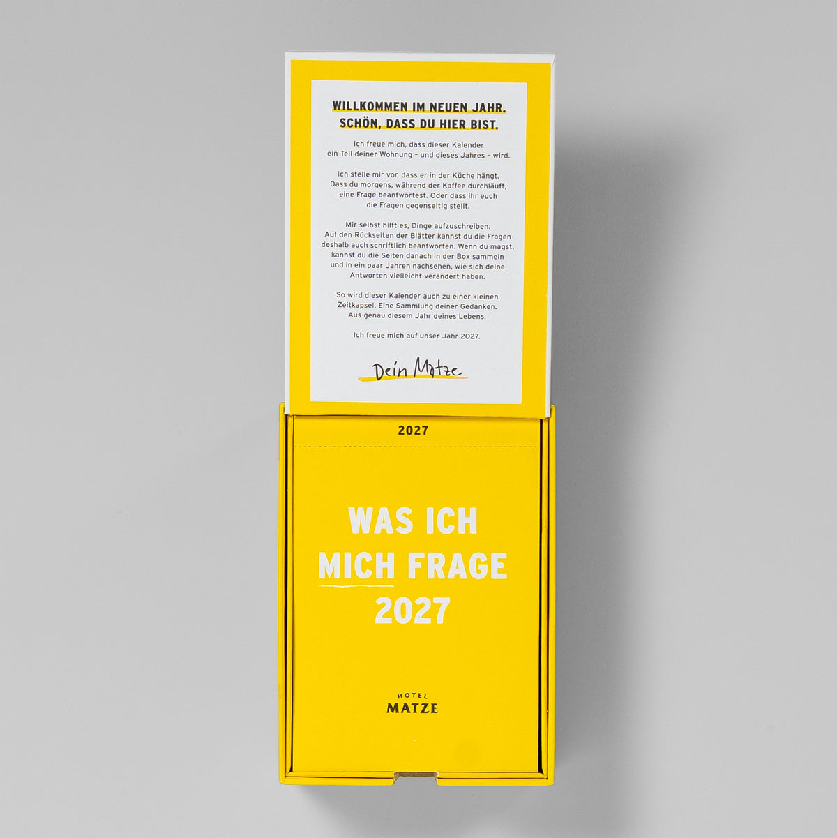 Geöffnete Box von oben: im Deckel »Willkommen im neuen Jahr«, darunter der Kalenderblock mit Titelblatt