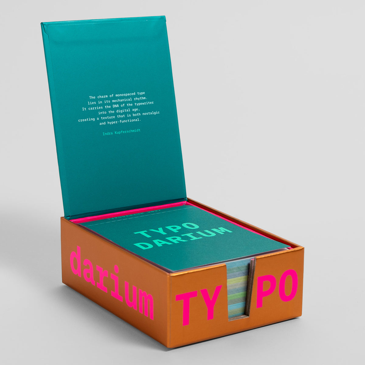 Aufgeklappte Typodarium-Box mit Deckeltext zu Monospace-Schriften und dem Kalenderblock im pinken Fach