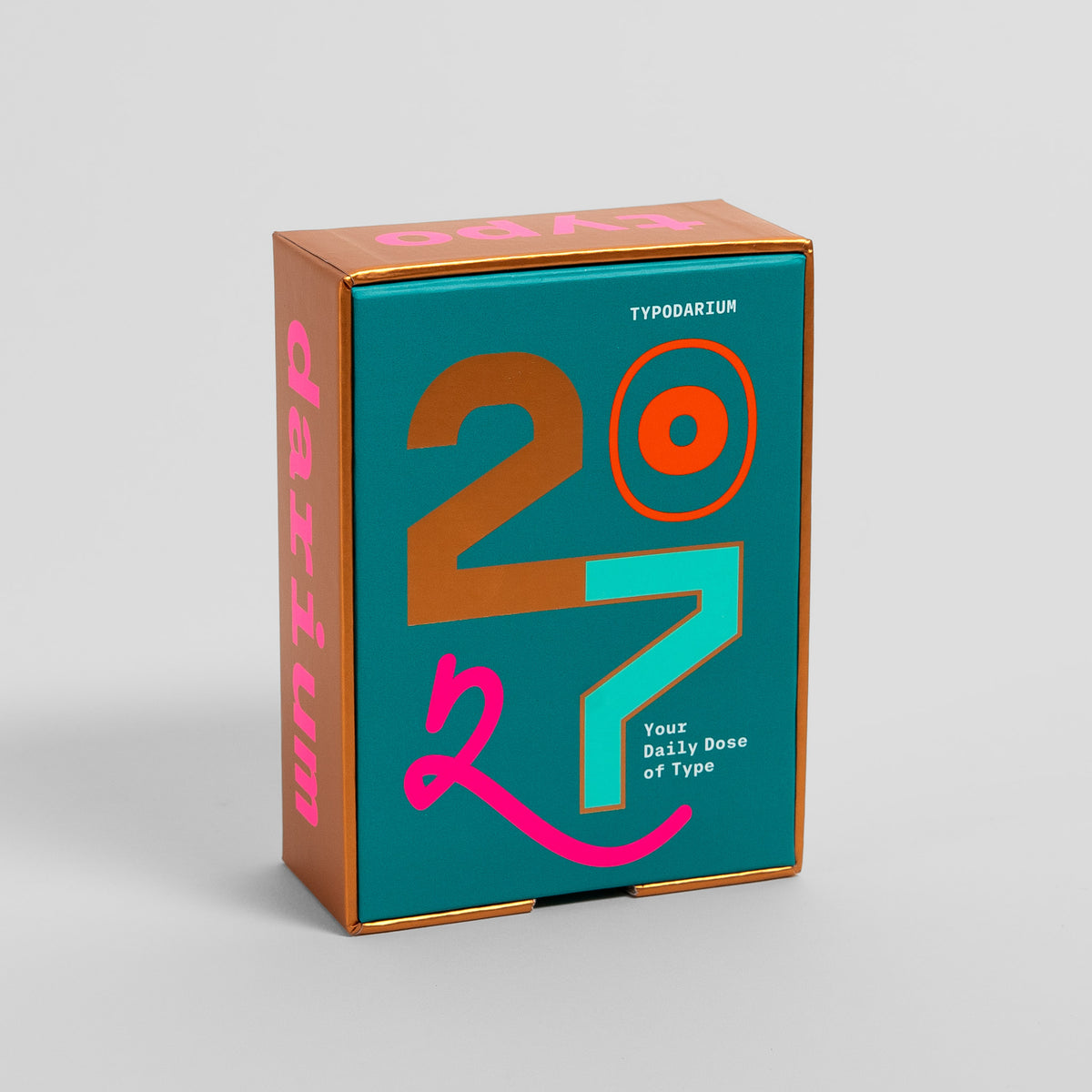 Typodarium 2027 vom Verlag Hermann Schmidt: Sammelbox mit Typo-Darium-Schriftzug in Pink auf Kupfer