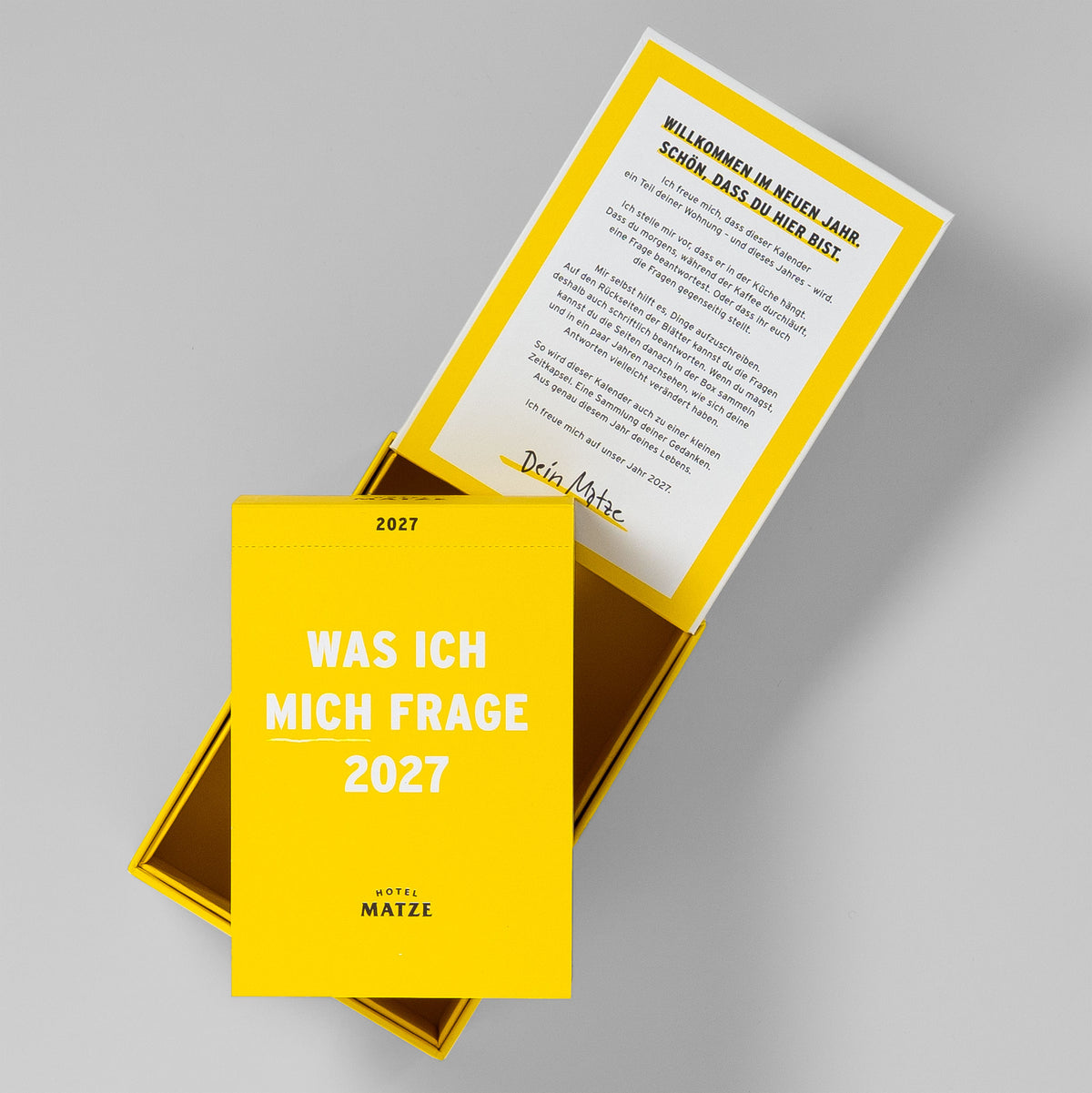 Kalenderblock vor der geöffneten Box, im Deckel der Willkommenstext von Matze