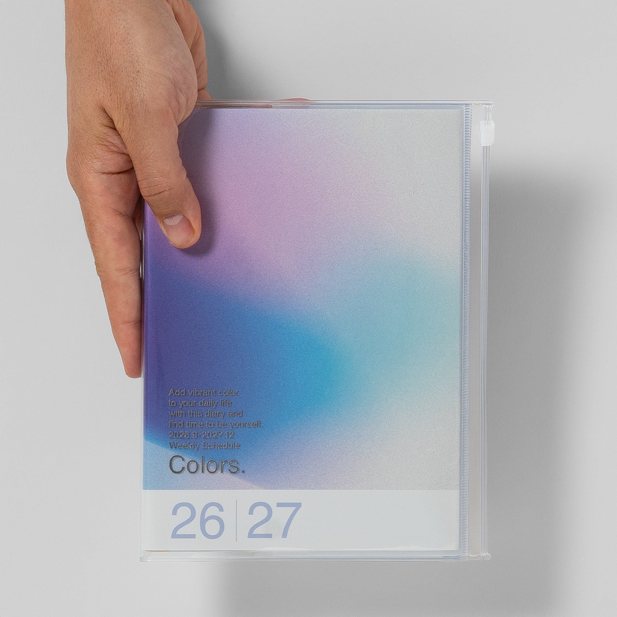 Mark's Taschenkalender A5 2026/27 Verlauf „Colors." Größenvergleich mit Hand, Farbe Blau