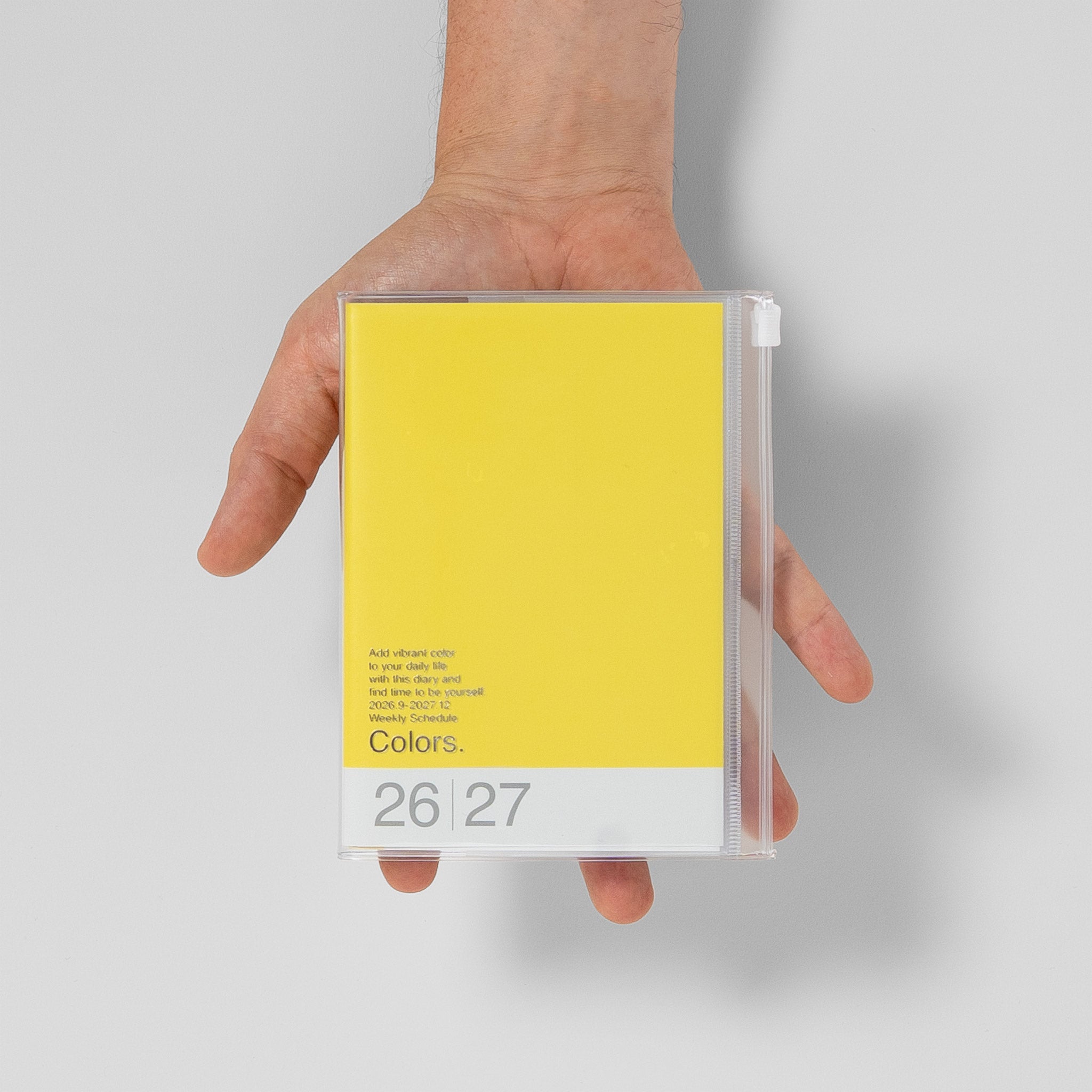 Mark's Taschenkalender A6 2026/27 Größenvergleich mit Hand, Farbe Gelb