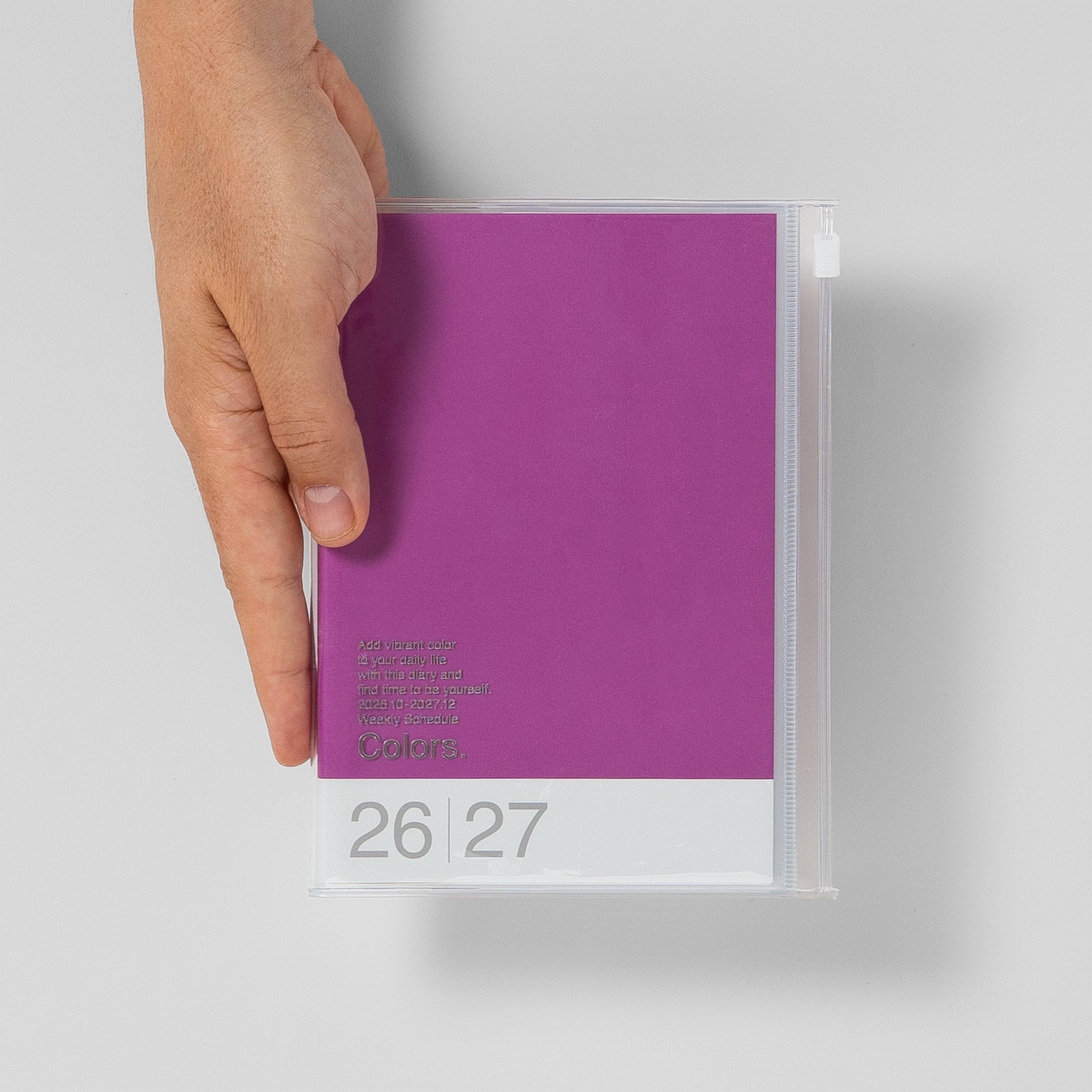 Mark's Taschenkalender B6 2026/27 Größenvergleich mit Hand, Farbe Violett #Farbe_Purple