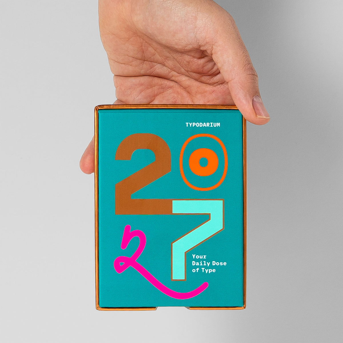 Typodarium-Box in einer Hand gehalten, das handliche Format des Abreißkalenders im Größenvergleich